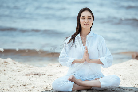 印尼封印摄影照片_迷人的年轻亚洲妇女在安贾莉手印 (称呼封印) 在海滩上的姿势