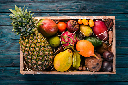 热带水果装在木箱里.木瓜、龙果、羊肉、罗望子、仙人掌果、鳄梨、格拉纳地拉、木薯、苦瓜、芒果、芒果、西番莲、椰子.