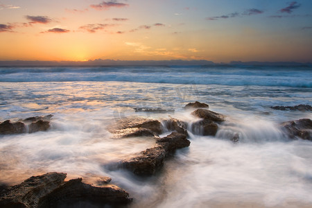 日出景观的海洋与波浪云彩和岩石