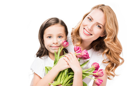 国际幸福日摄影照片_幸福的母亲和小女儿的肖像与花束的花朵隔离在白色, 母亲节的概念