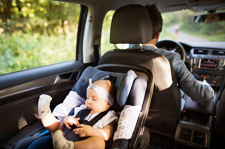 父亲节汽车摄影照片_不可识别的男子驾驶与一名女婴.