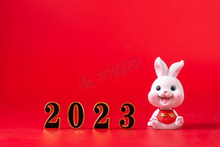 兔年微信公众号首图摄影照片_新年2023陶瓷兔子红色背景上摆放摄影图配图