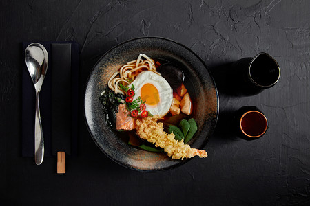 海鲜拉面摄影照片_美味的传统日本汤用筷子和勺子的顶部视图 
