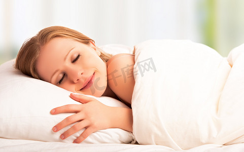 年轻笑容摄影照片_美丽的女人睡觉和他睡在床上的笑容