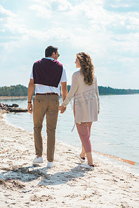 情侣牵着手摄影照片_浪漫情侣牵着手走在沙河边
