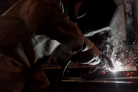 工厂生产工人焊接金属的裁剪图像 