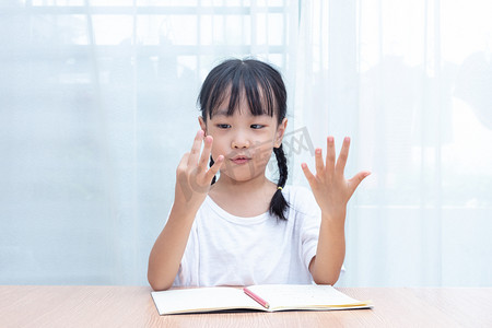 亚洲小中国女孩在家里数手指算术