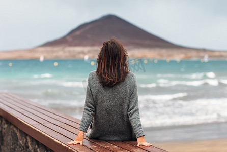 大海旅行摄影照片_年轻女子的背观享受大海。放松观念。富埃特文图拉岛民, 加那利群岛, 西班牙. 