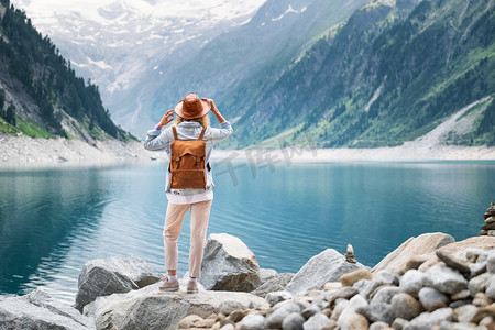 湖人摄影照片_旅行者看山湖。旅行和积极的生活理念。冒险和旅行在山区域在奥地利