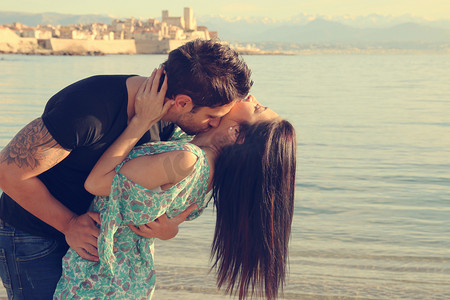 对年轻的夫妇在海滩上的吻