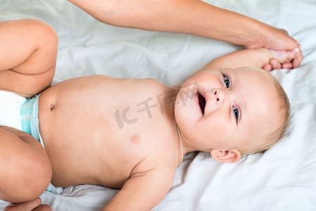 护士按摩摄影照片_婴儿保健按摩。母亲按摩婴儿腹部