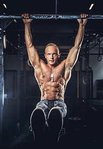 体操运动员单杠摄影照片_在军事的裤子光着膀子肌肉男.