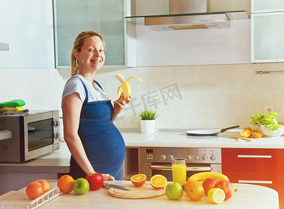 孕妇在厨房里吃香蕉 