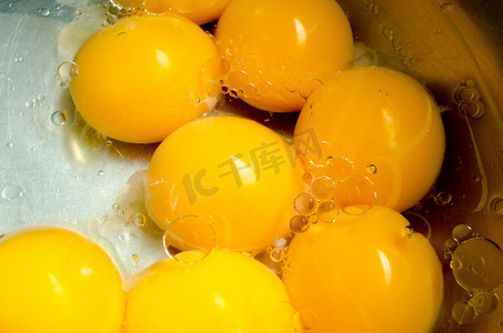 蛋黄摄影照片_生鸡蛋蛋黄在植物油。准备去做饭