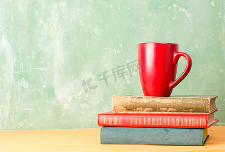 红色手册手册摄影照片_书籍和桌上的红色杯子 