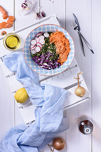 春天的新鲜排毒蔬菜沙拉在一个碗里，健康食品的概念。白色的木制背景。素食餐. 