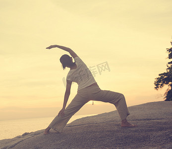 生活境界摄影照片_在海滩上练习瑜伽的女人
