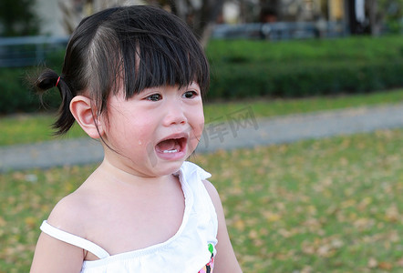特写可爱的小女孩在公园里哭.