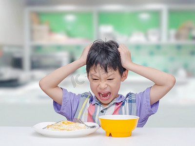 吃男孩摄影照片_亚洲孩子不想吃午餐的食物