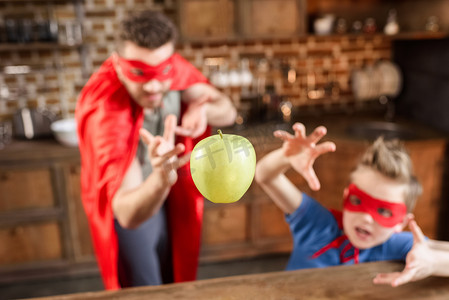 father and son in red superhero costumes