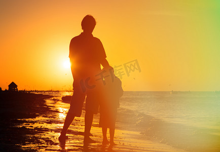 人拥抱剪影摄影照片_父亲和儿子拥抱在日落时分