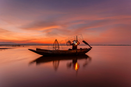 柬埔寨渔民摄影照片_传统渔民在日出的时候，缅甸抛网捕鱼茵莱湖