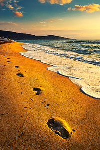 日落时在海滩上的脚印