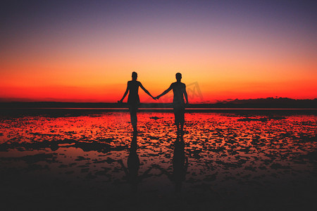 夫妇手牵着手在日落时分的爱情