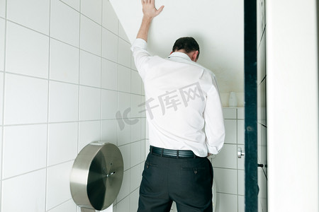 雄性摄影照片_在厕所里撒尿的人