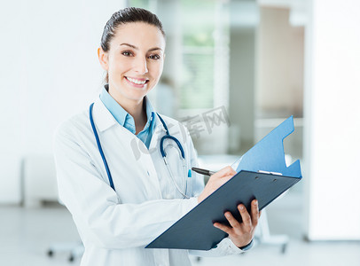 预防疾病知识摄影照片_面带笑容的女医生抱着医疗记录