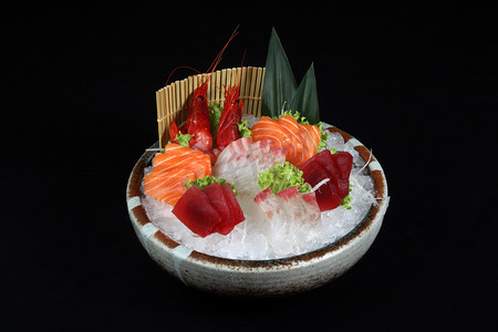金枪鱼卷寿司摄影照片_与冰和装饰的蔬菜混合的寿司