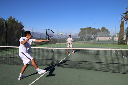 打假日摄影照片_两名男子在夏天打网球
