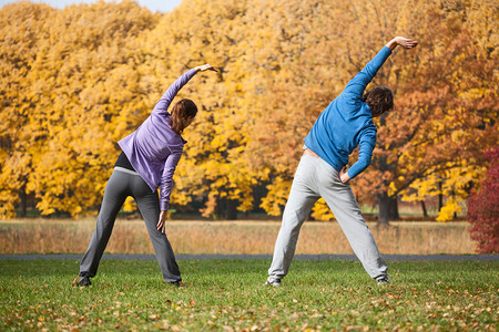 在秋天在公园锻炼身体的夫妇