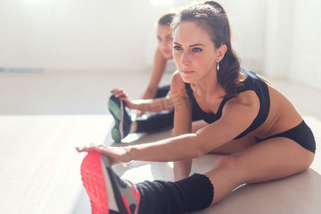 群适合妇女工作拉伸腿部肌肉回去热身在健身房健身、 运动、 训练和生活方式的概念.