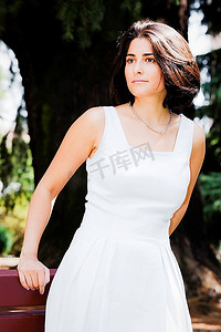 一位年轻的拉丁女孩的垂直肖像，黑发，穿着白色衣服