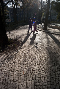 两名妇女走在坎波德乌里克里斯本小镇广场的鹅卵石小路上。
