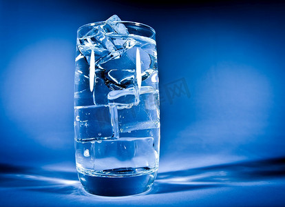 深蓝色背景上的一杯加冰的水