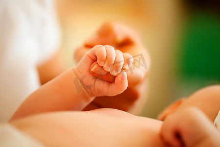 吉祥物猴宝宝摄影照片_宝宝抓住照顾她的妈妈的手(焦点在手上)