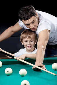 球池摄影照片_带着儿子的年轻人打台球