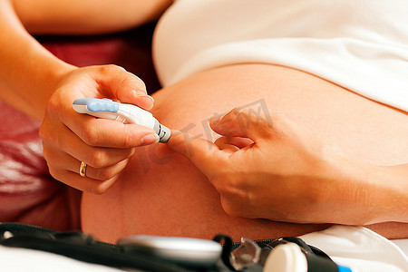 孕妇摄影照片_一名孕妇从手指上取血进行血糖水平测试，以确定她是否患有妊娠期糖尿病