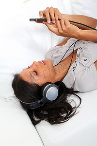 拉丁文摄影照片_美丽的拉丁女孩戴着耳机听音乐