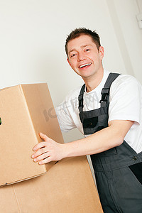 装东西的男人摄影照片_搬运搬运箱，里面装着搬进新家的人们需要的许多东西