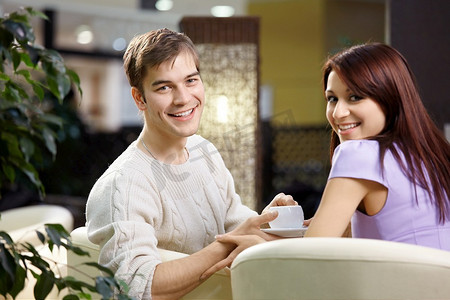 幸福的一对笑容满面的恋人在咖啡馆共进晚餐