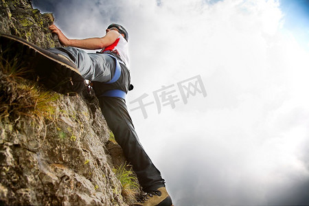 攀岩色彩摄影照片_白人年轻男性攀岩者，夏季，俯视，水平框架，色彩鲜艳，背光，右侧复制空间