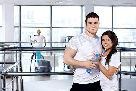 幸福的年轻夫妇在健身俱乐部对抗训练模拟器