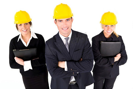 一个工业概念拍摄显示2名妇女和一名男子穿着安全帽。焦点集中在前景的男人身上