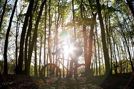 一名男性山地自行车手在森林中的一条单车道上行驶。模糊效果
