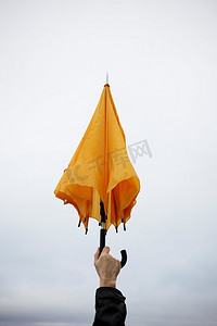 男人的手撑着黄色的伞，选择性地聚焦在手指上(对许多主题来说都是很棒的抽象照片)