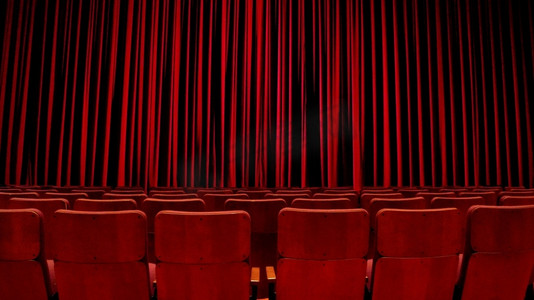 在紧闭的红色天鹅绒窗帘前，空荡荡的剧院座位。