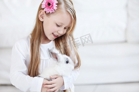 小女孩抱着一只毛茸茸的白兔
